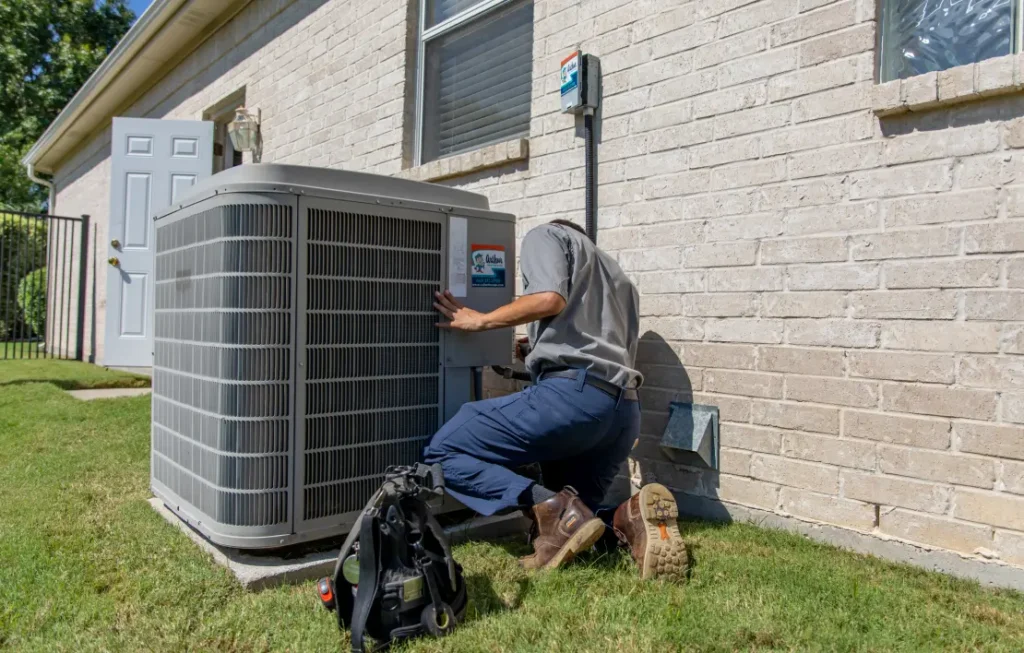 HVAC technician inspecting residential outdoor air conditioning unit